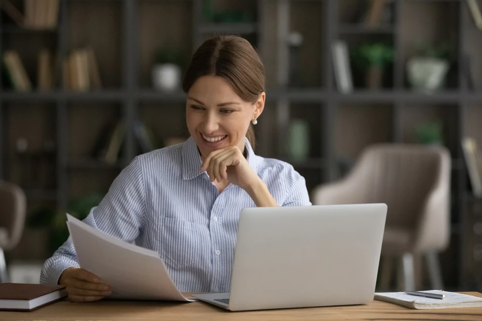 Une personne en costume signe un document contractuel avec un stylo métallique dans un environnement de bureau professionnel